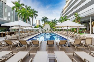 Una piscina al aire libre, sillones reclinables de piscina