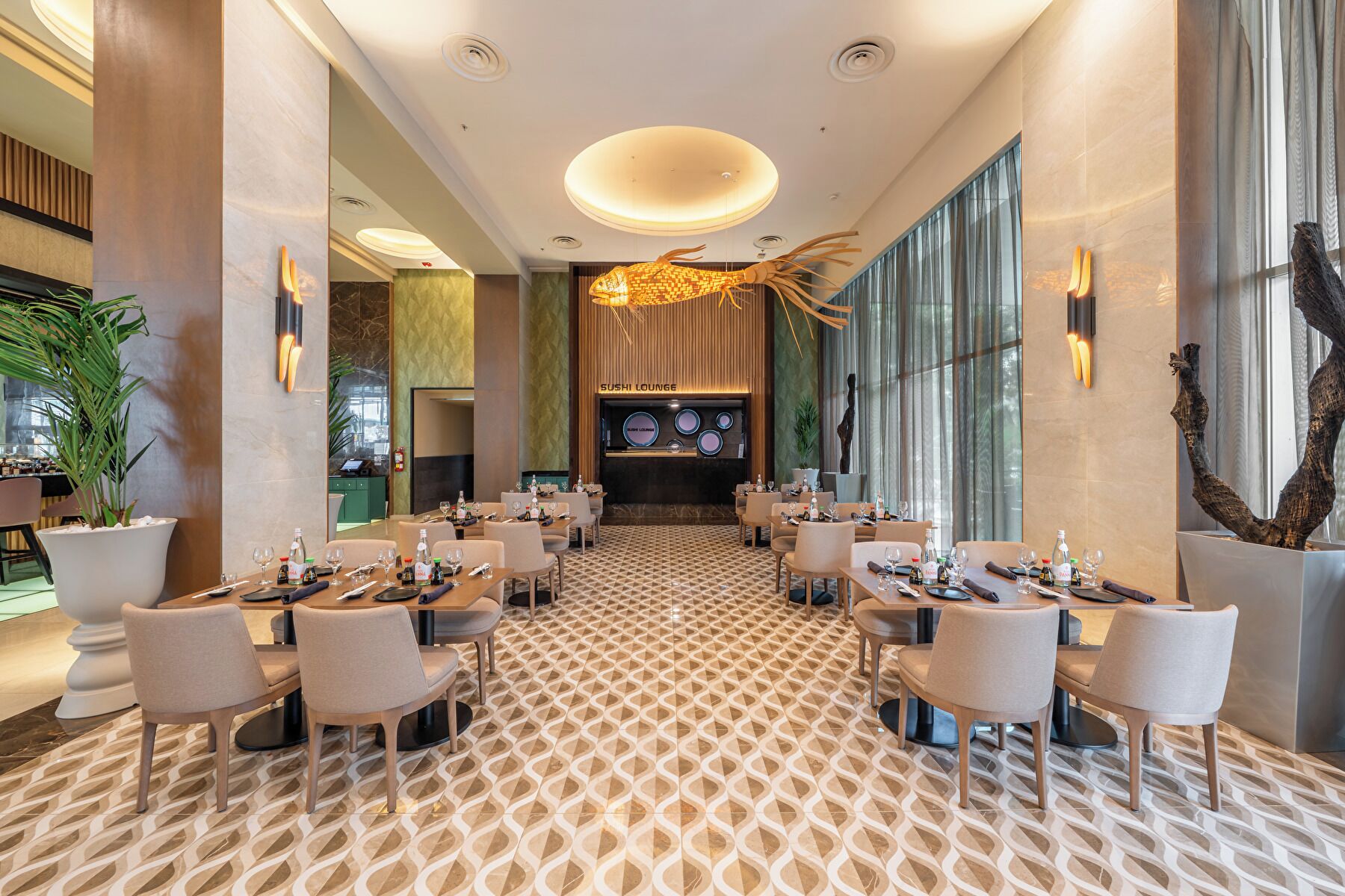 A modern restaurant with a patterned floor, multiple tables, and chairs.