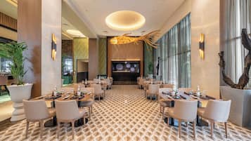 Een modern restaurant met een patroonvloer, meerdere tafels en stoelen.