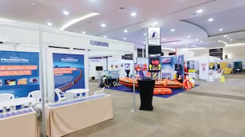 A trade show booth with a marine hose specialist display, tables, and chairs for attendees.