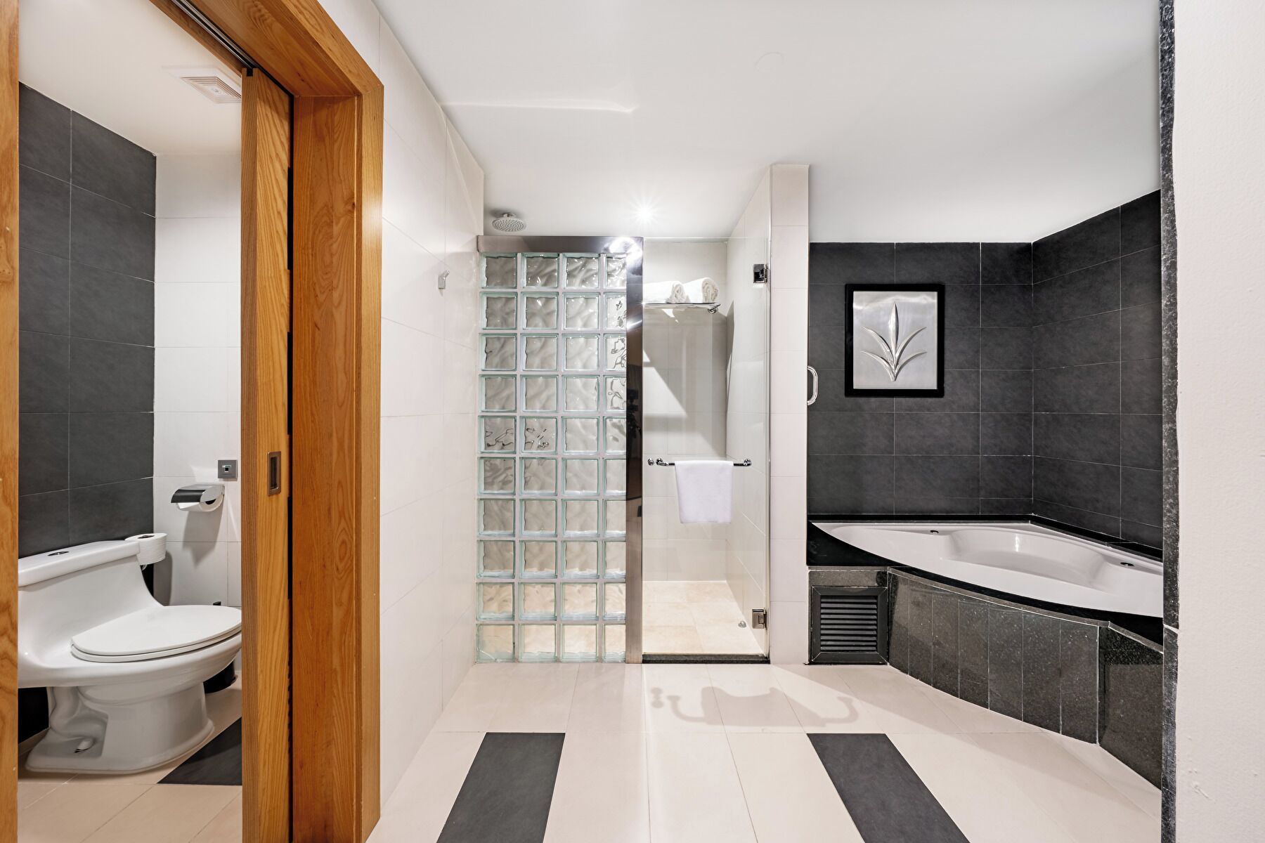 A modern bathroom with a toilet, shower, and bathtub.