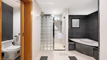 A modern bathroom with a toilet, shower, and bathtub.