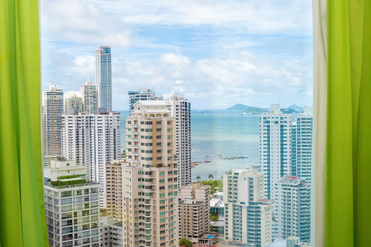 Un complejo de edificios altos con múltiples pisos, ventanas amplias y vista al mar.