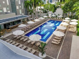 Una piscina al aire libre, sillones reclinables de piscina