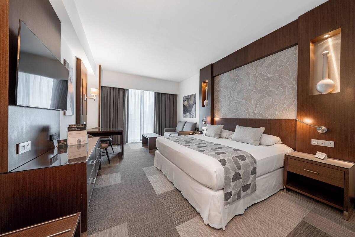 Habitación familiar con cama King | Minibar, caja fuerte, escritorio y espacio para trabajar con un portátil