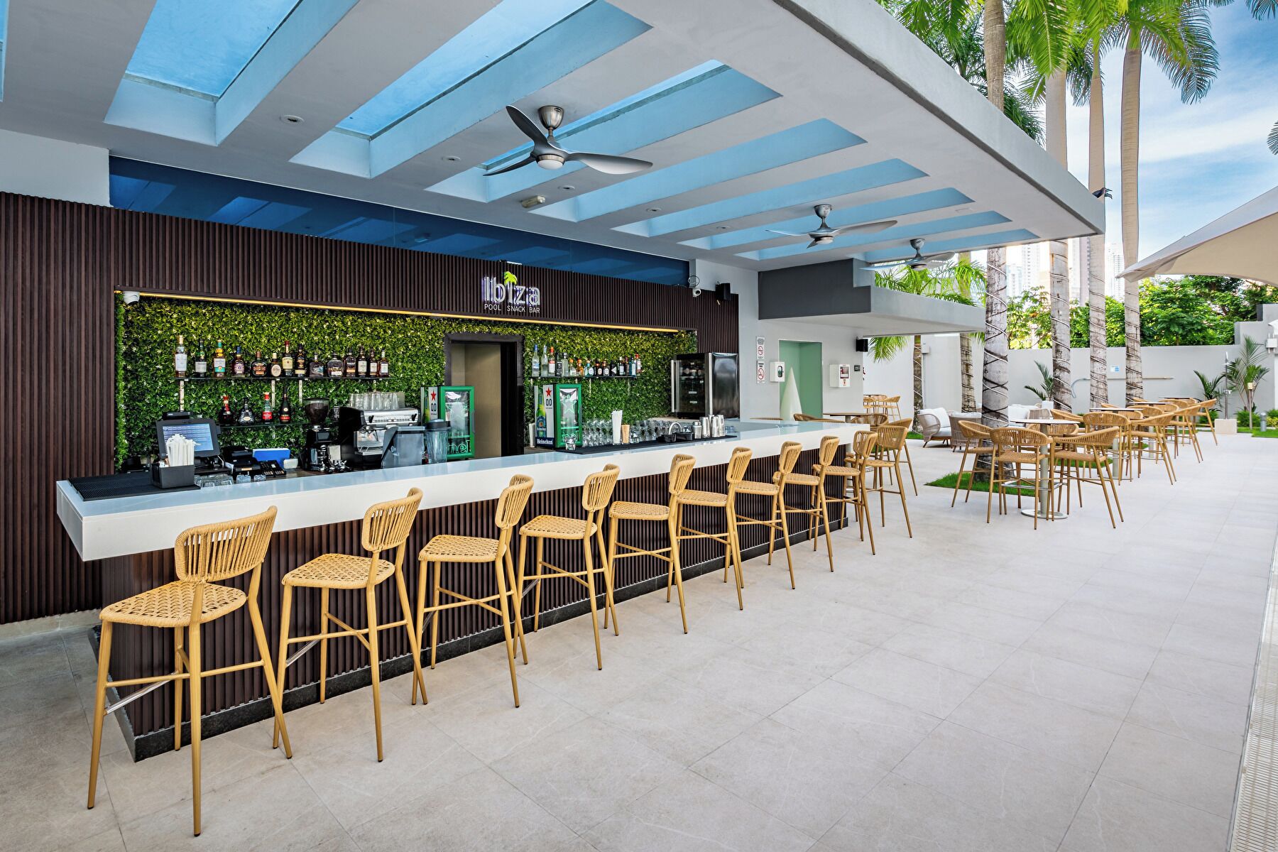 Un espace bar avec un comptoir, des tabourets de bar et un ventilateur de plafond.