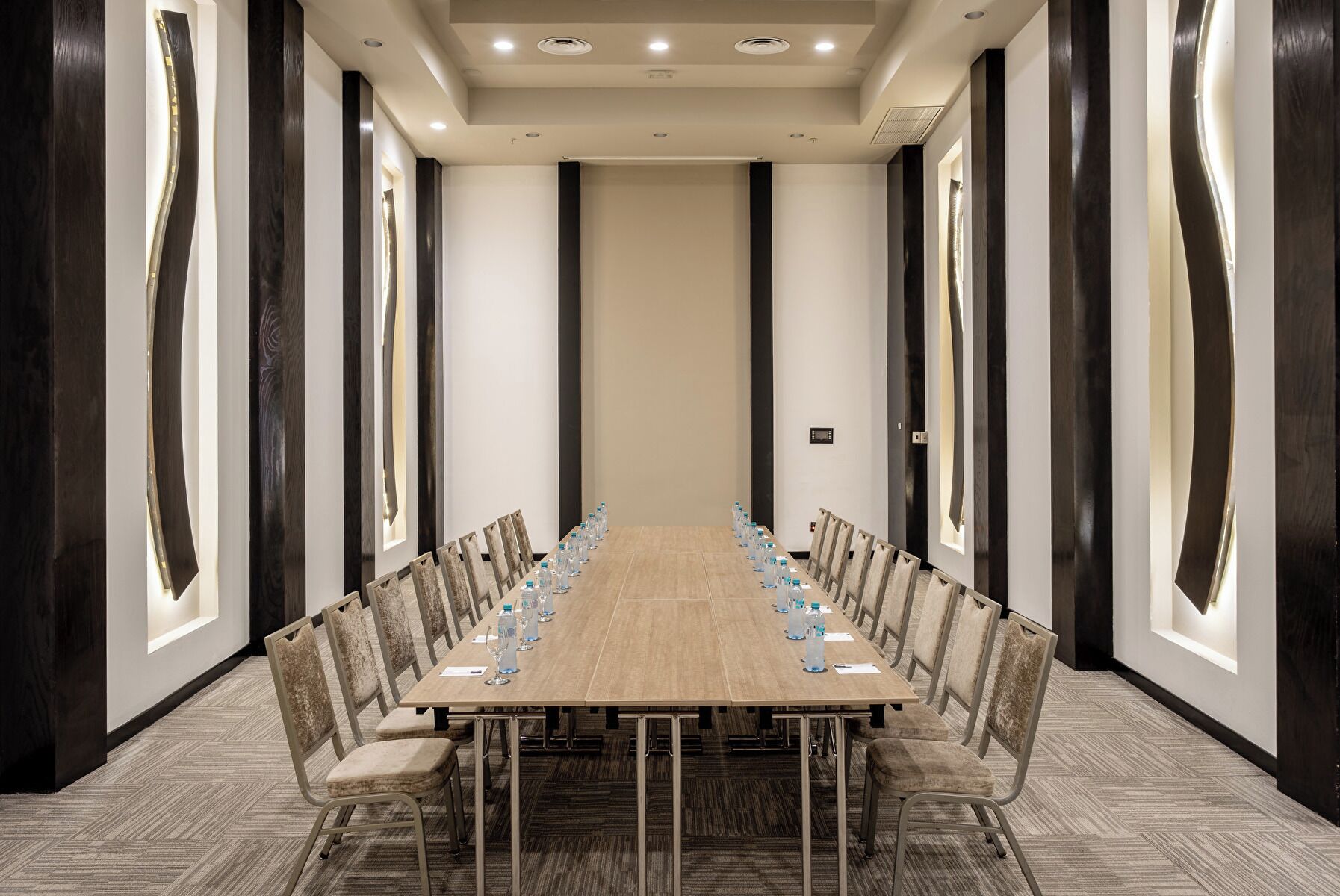 A conference room with a long table, chairs, and water bottles.