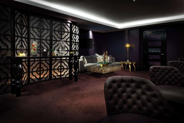 A dark-themed living room with a sectional sofa, a coffee table, and decorative items.