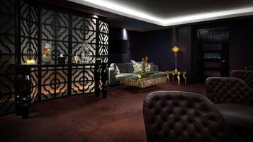 A modern living room with a dark color scheme, a sectional sofa, a coffee table, and decorative items.