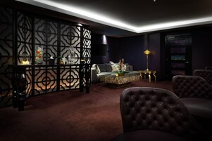Un salón moderno con una paleta de colores oscuros, un sofá modular, una mesa de centro y objetos decorativos.