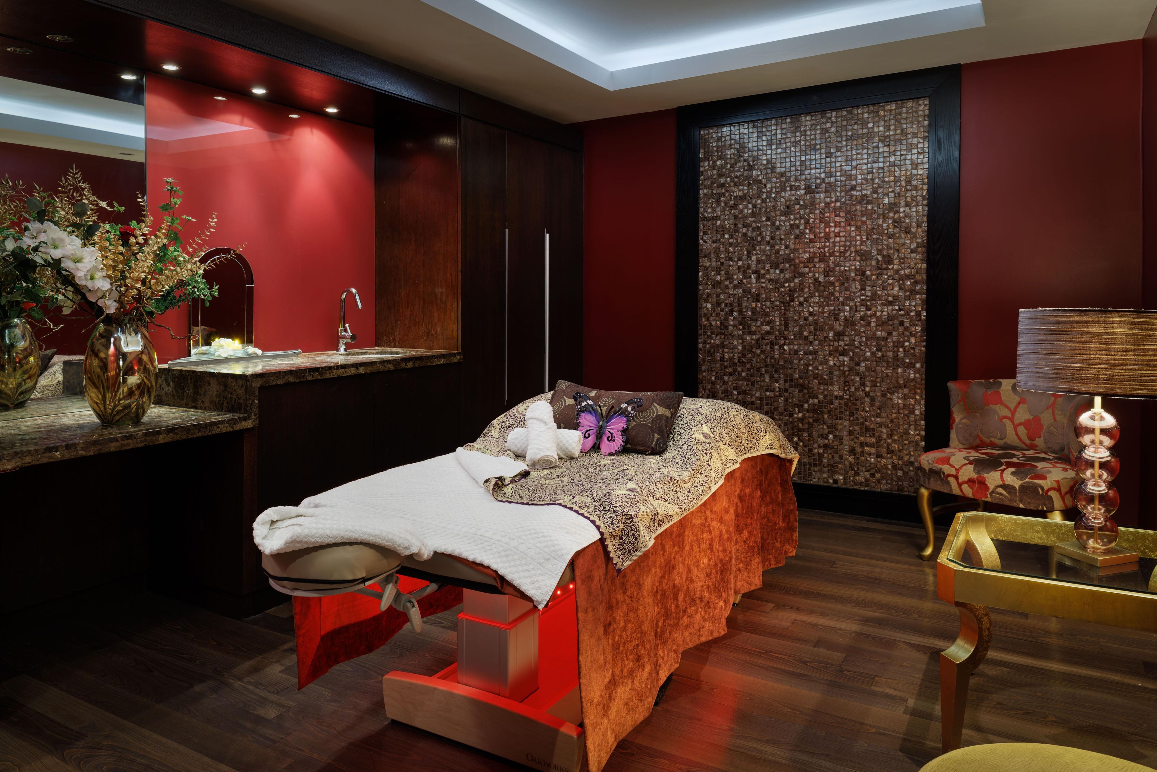 A modern bedroom with a bed, bedside table, and a decorative wall.