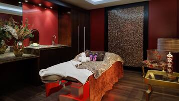 A modern bedroom with a bed, bedside table, and a decorative wall.