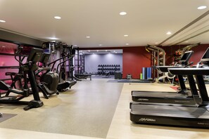 A gym with treadmills, weight machines, and a wall of dumbbells. - Hilton London Syon Park (Brentford)