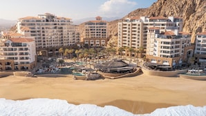 A beachfront hotel with multiple buildings, a pool area, and a rocky hillside backdrop. - Grand Solmar Lands End Resort And Spa (Cabo San Lucas)