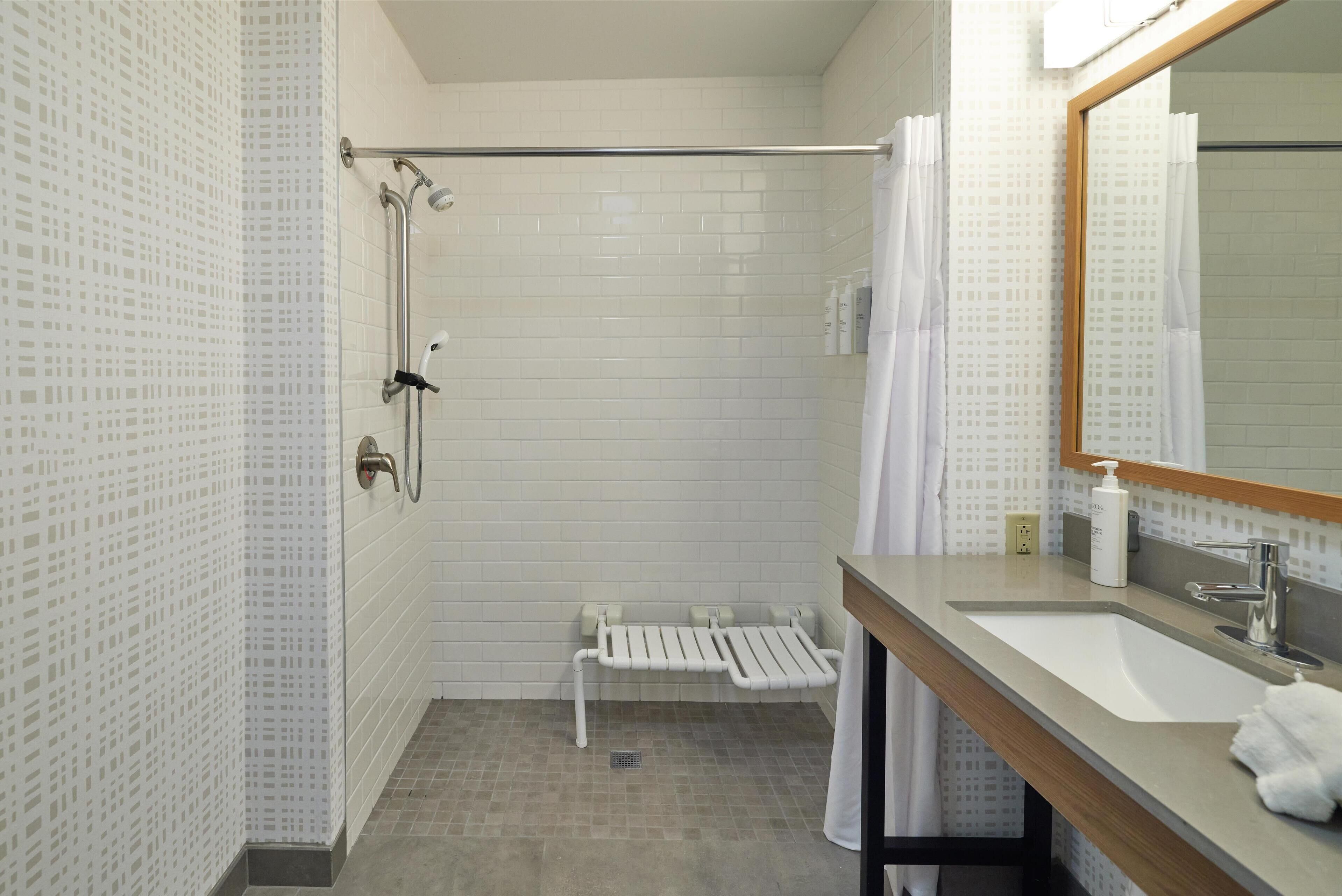 A modern bathroom with a shower, toilet, and sink.