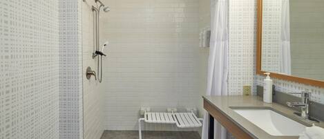A modern bathroom with a shower, toilet, and sink.