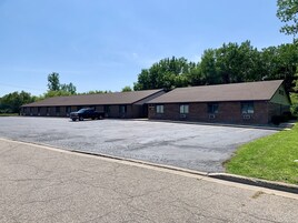 A motel with a parking lot and a single-story building.