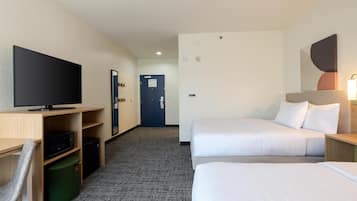 Habitación de hotel con dos camas, un escritorio, televisor, microondas y un cubo de basura.