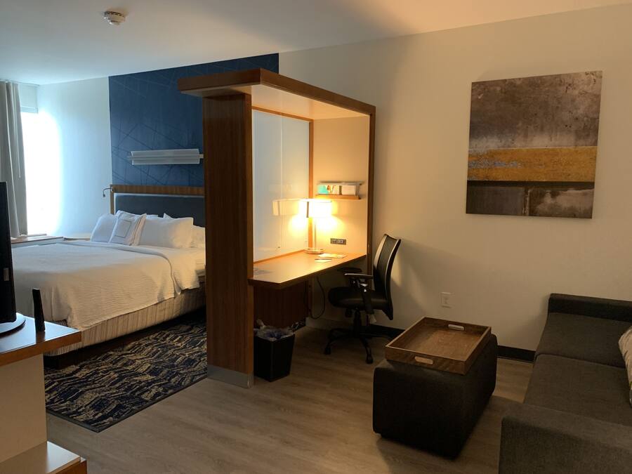 Ein Hotelzimmer mit Bett, Schreibtisch, Stuhl und einer kleinen Sitzecke.