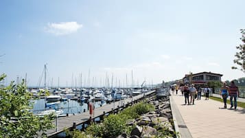 Ein Yachthafen mit vertäuten Booten, einem Holzsteg und einem Gebäude im Hintergrund.