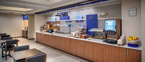 A modern breakfast bar with a coffee machine, a fruit bowl, and a sign that reads "SQUEEZE THE DAY".