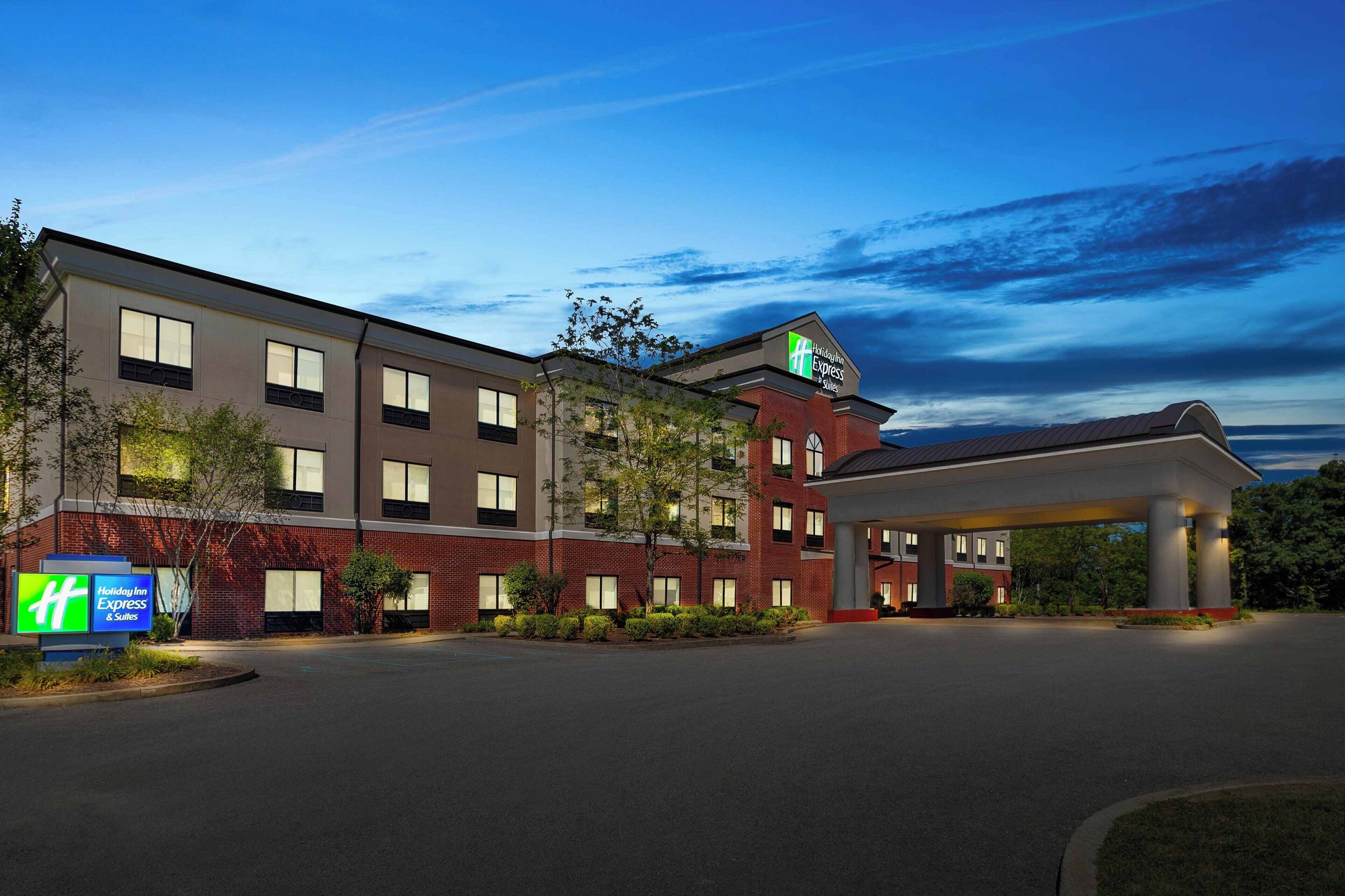 A Holiday Inn Express hotel with a brick facade, multiple windows, and a covered parking area.