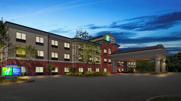 A Holiday Inn Express hotel with a brick facade, multiple windows, and a covered parking area.