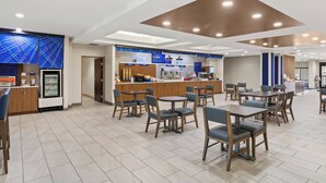 A modern hotel lobby with a breakfast bar, seating area, and a refrigerator. - Holiday Inn Express and Suites Fairmont by IHG (Fairmont)