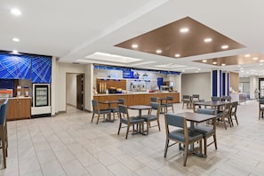A modern hotel lobby with a breakfast bar, seating area, and a refrigerator. - Holiday Inn Express and Suites Fairmont by IHG (Fairmont)