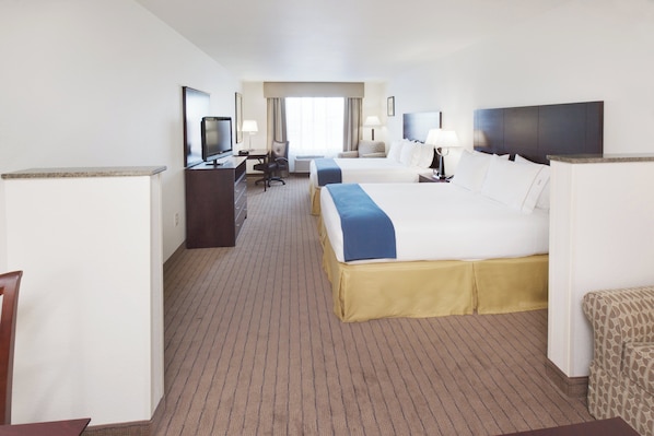 Quarto de hotel com duas camas, uma mesa, uma televisão e uma cadeira.
