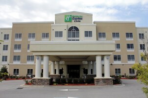 Un hotel Holiday Inn Express & Suites con entrada central, varios pisos y techo plano.