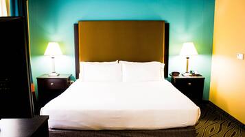 A hotel room with a large bed, two bedside tables with lamps, and a nightstand with a telephone.