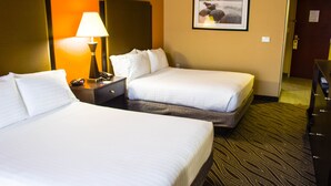 A hotel room with two beds, a nightstand with a lamp, a framed picture on the wall, and a door leading to another room. - Holiday Inn Express Havelock NW- New Bern by IHG (Havelock)