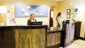 A reception desk with a modern design, a digital screen, and a sign indicating 'Holiday Inn Express'.