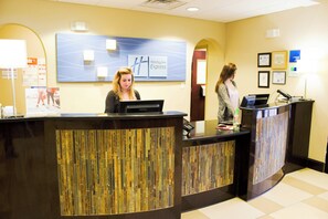 A reception desk with a modern design, a digital screen, and a sign indicating 'Holiday Inn Express'. - Holiday Inn Express Havelock NW- New Bern by IHG (Havelock)