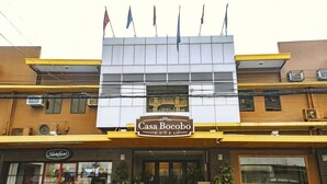 A hotel named Casa Bocobo with a modern facade, multiple flags, and a signboard. - Casa Bocobo Hotel (Manila)
