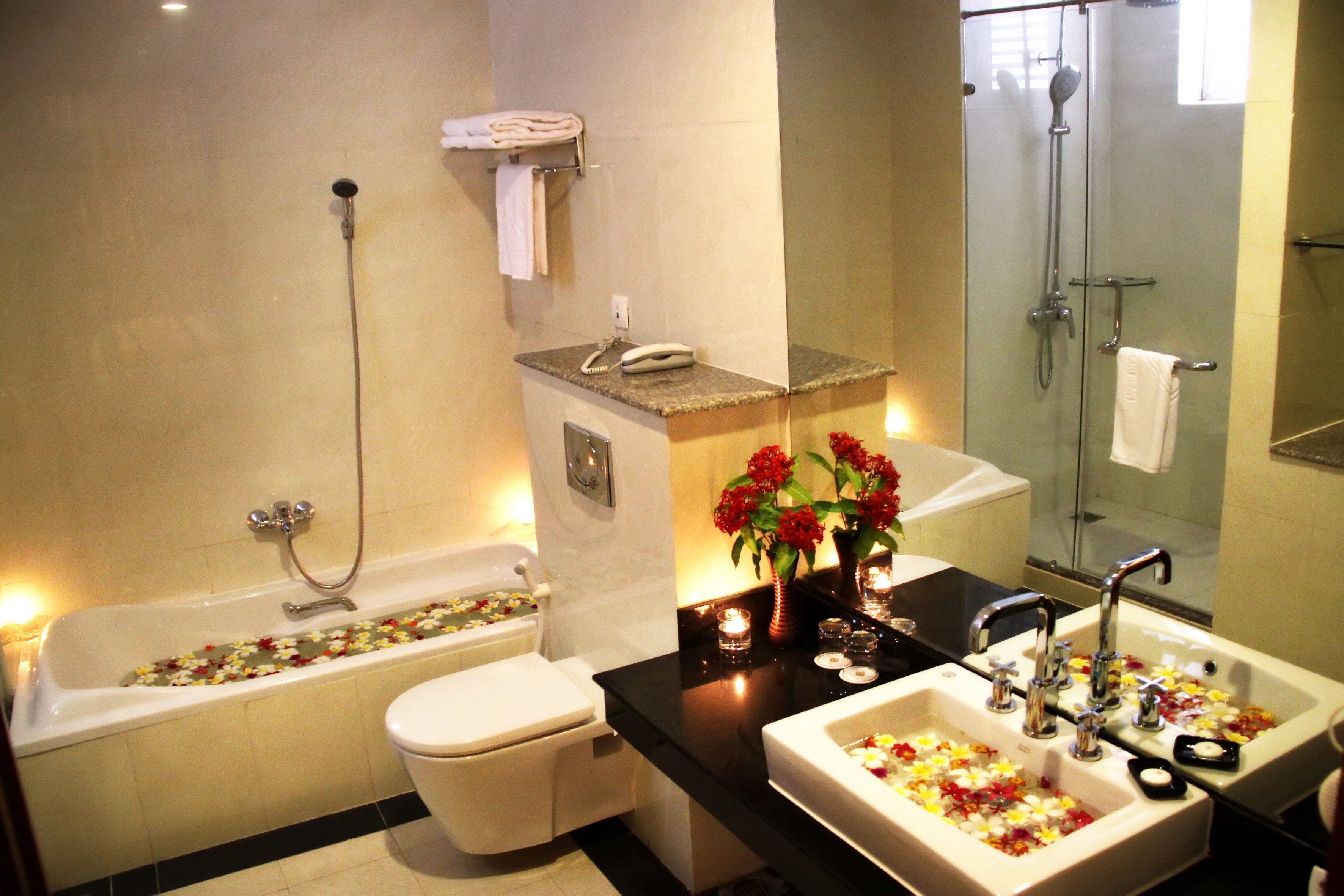 A modern bathroom with a bathtub, toilet, and a shower area.