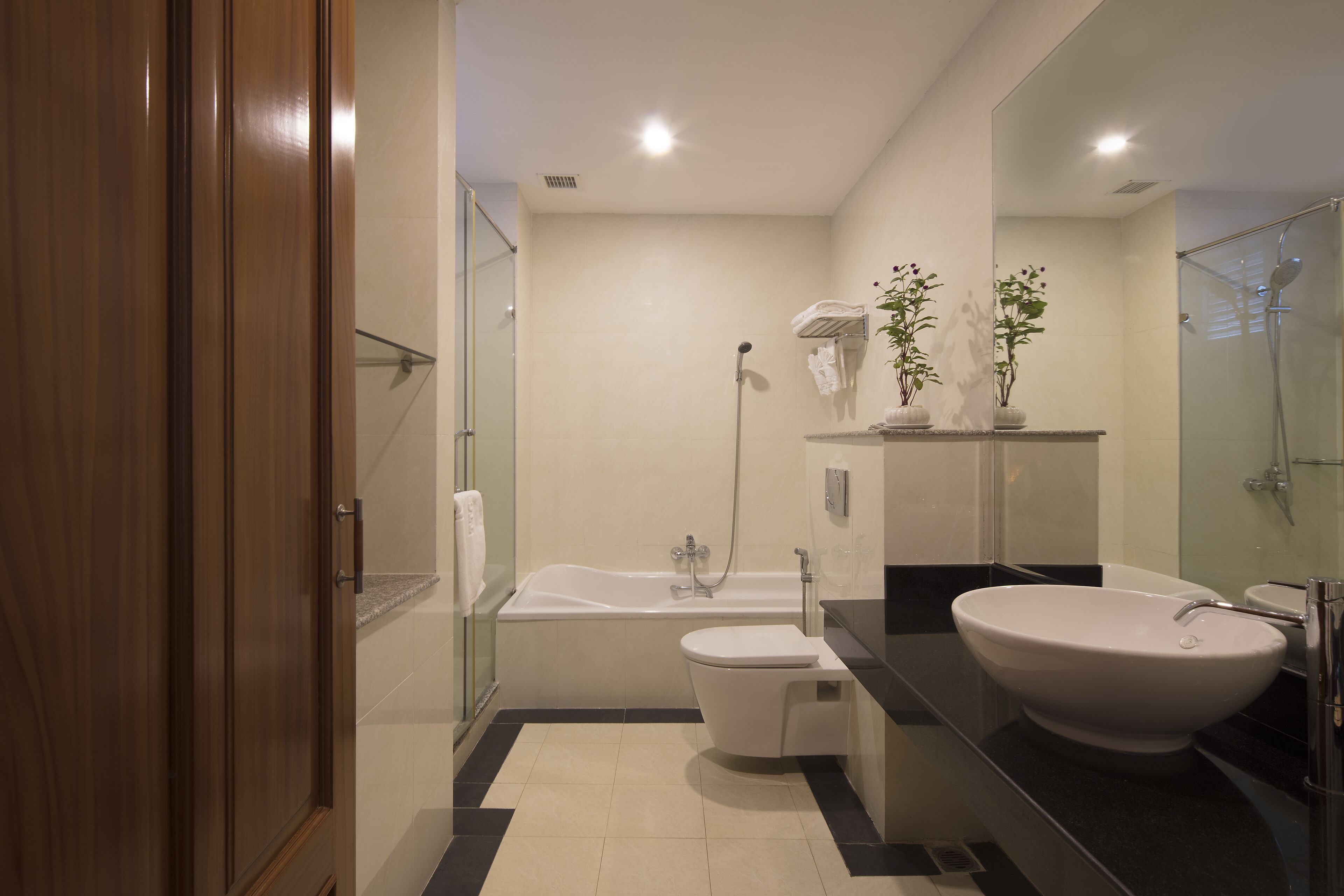 A modern bathroom with a bathtub, toilet, and large sink.