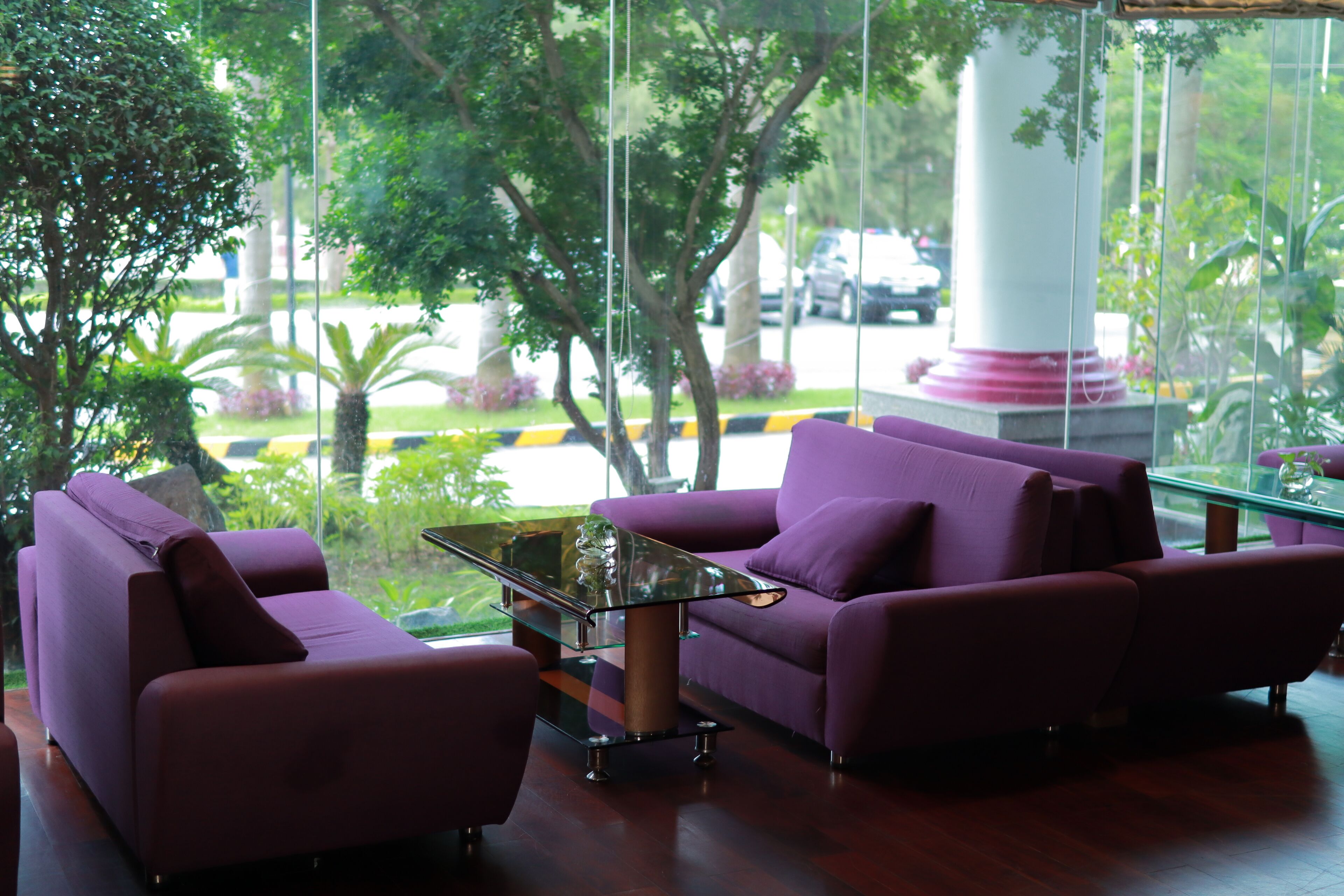 A modern interior with purple sofas and a glass coffee table.