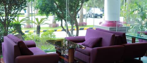 A modern interior with purple sofas and a glass coffee table.