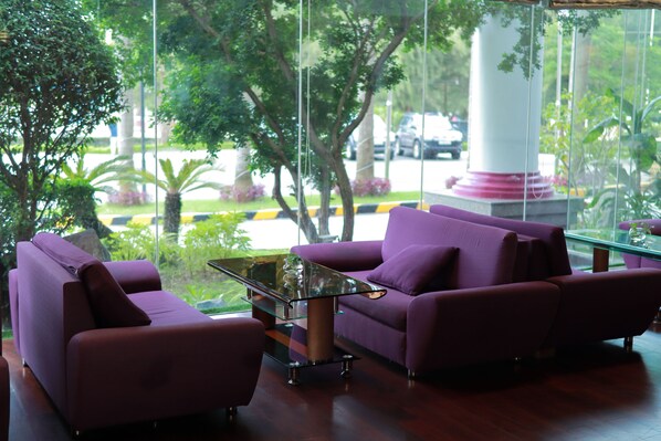 A modern interior with purple sofas and a glass coffee table. - TTC Hotel - Phan Thiet (Phan Thiet)