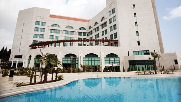 Um edifício grande com uma piscina em frente.