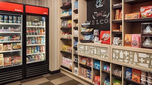 A candy and snack display in a store with shelves stocked with various brands and types of candies and snacks.