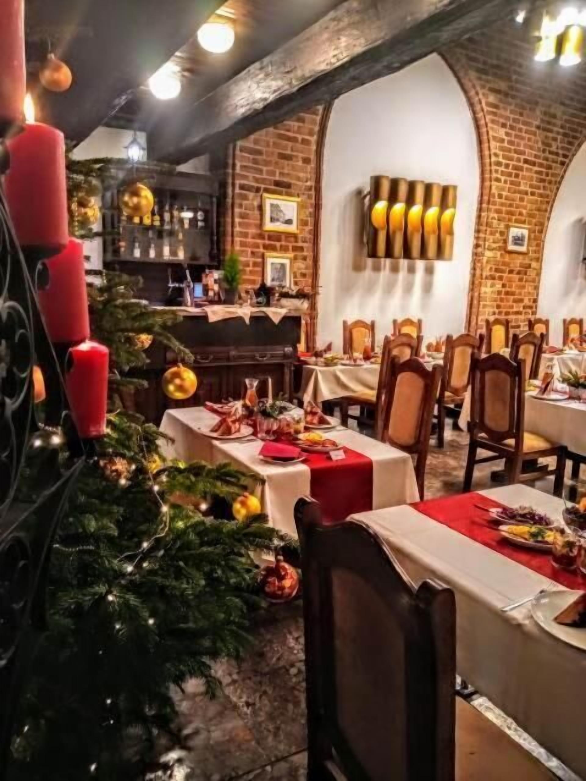 A restaurant with brick walls, wooden furniture, and Christmas decorations.