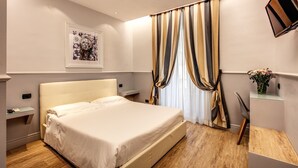 Un dormitorio con cama, mesitas de noche, escritorio y silla.