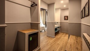 Un pasillo de hotel con suelo de madera, un radiador y un calentador fijado a la pared.