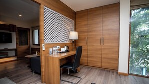 Una cocina moderna con armarios de madera, un comedor con una silla negra y vistas a la vegetación a través de un ventanal grande.