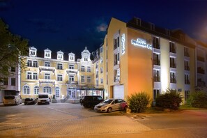 A hotel with a classic European architectural style, featuring multiple stories, balconies, and a well-lit facade. - Hotel Rheinischer Hof (Bad Soden am Taunus)