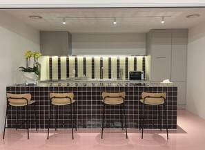 Geladeira, micro-ondas em uma área comum, chaleira elétrica