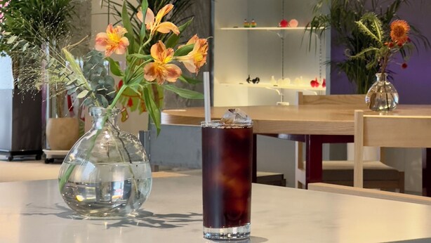A table with a vase of flowers and a glass of iced tea. - Hotel Tradiup by the Designers (Seoul)